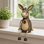 A rustic figurine of a donkey on a plank with rope legs hanging down