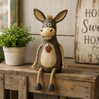 A rustic figurine of a donkey on a plank with rope legs hanging down